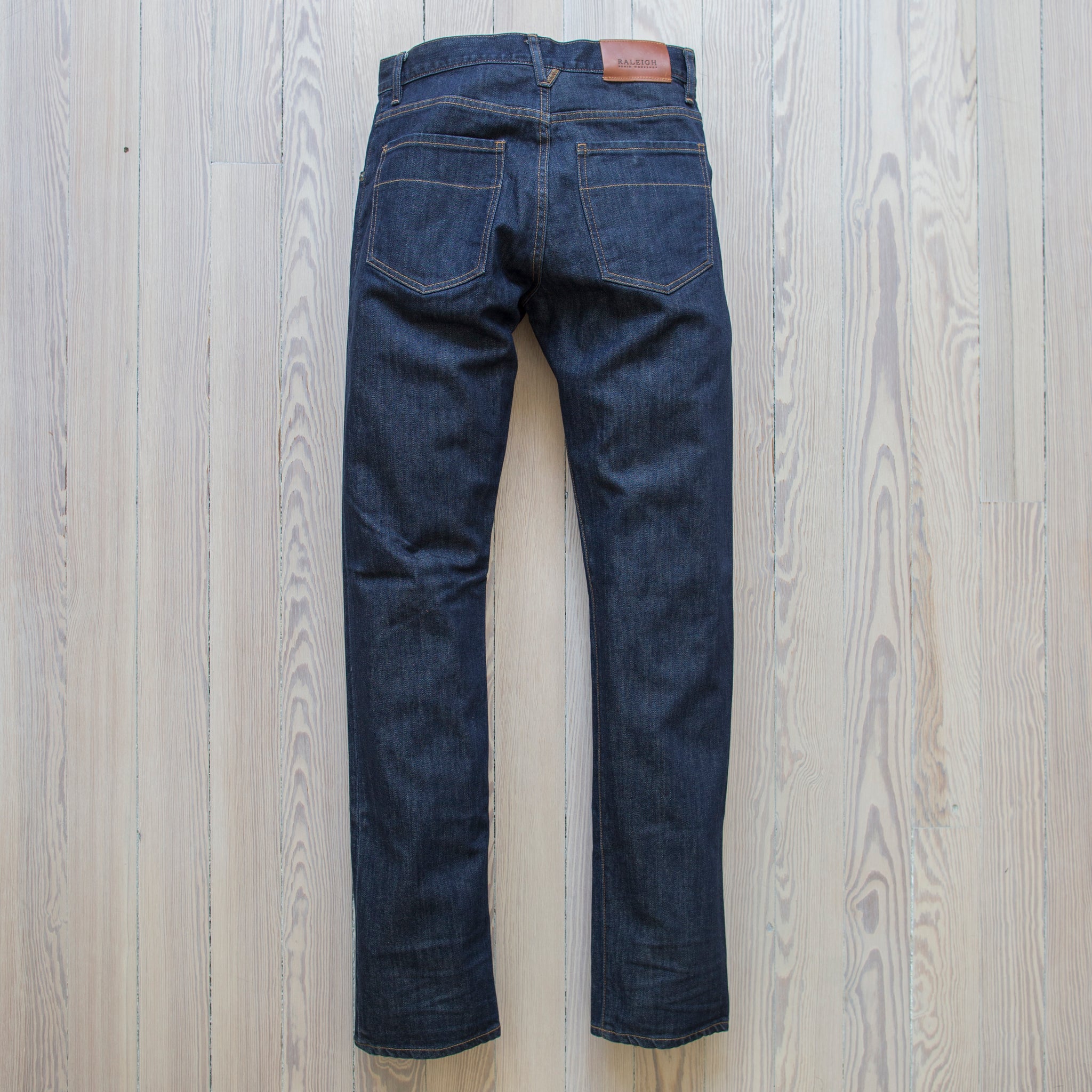 angle: resin rinse  Raleigh Denim Workshop Alexander work fit jeans with a dark wash, front view