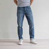 angle: pilot  A model wears Raleigh Denim Workshop Graham fit pants in blue, front view