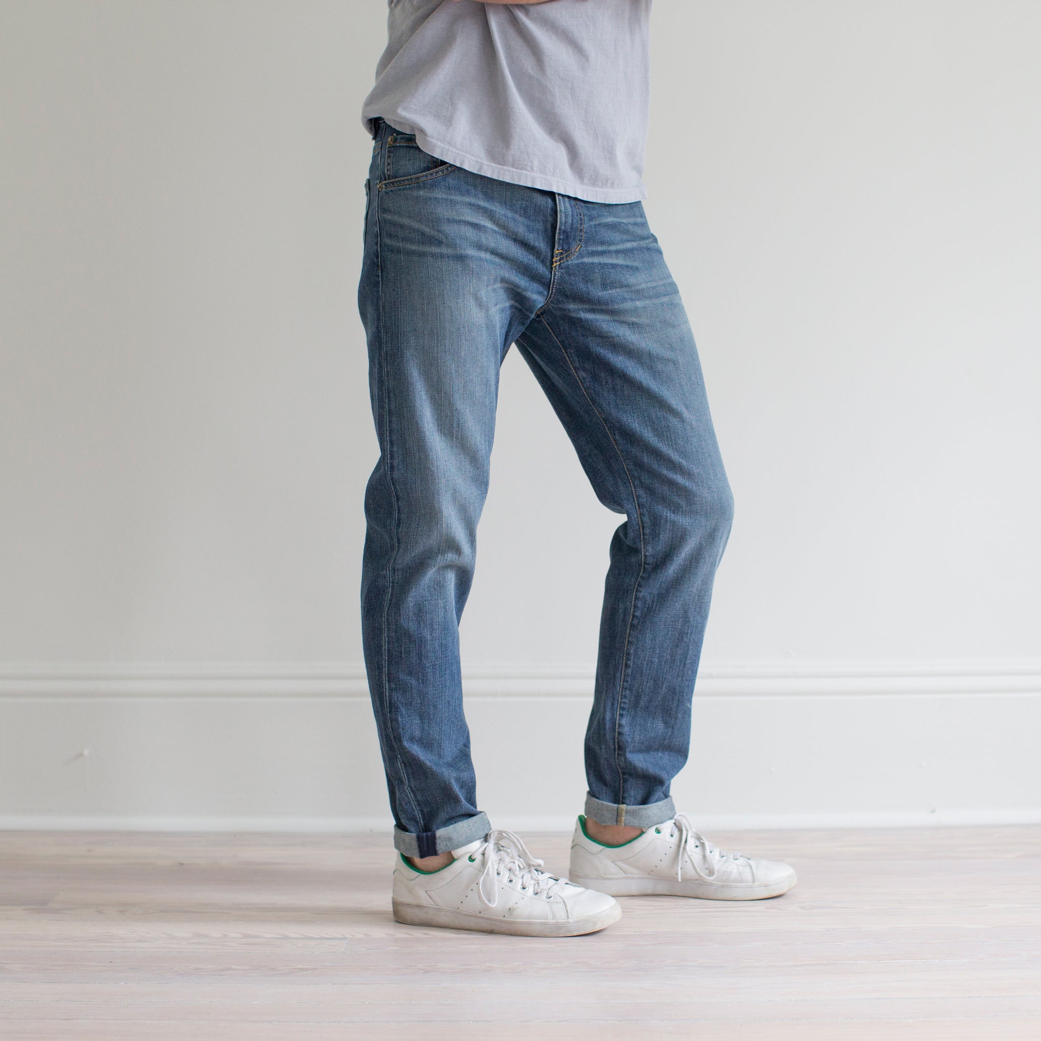 angle: pilot  A model wears Raleigh Denim Workshop Graham fit pants in blue, side view