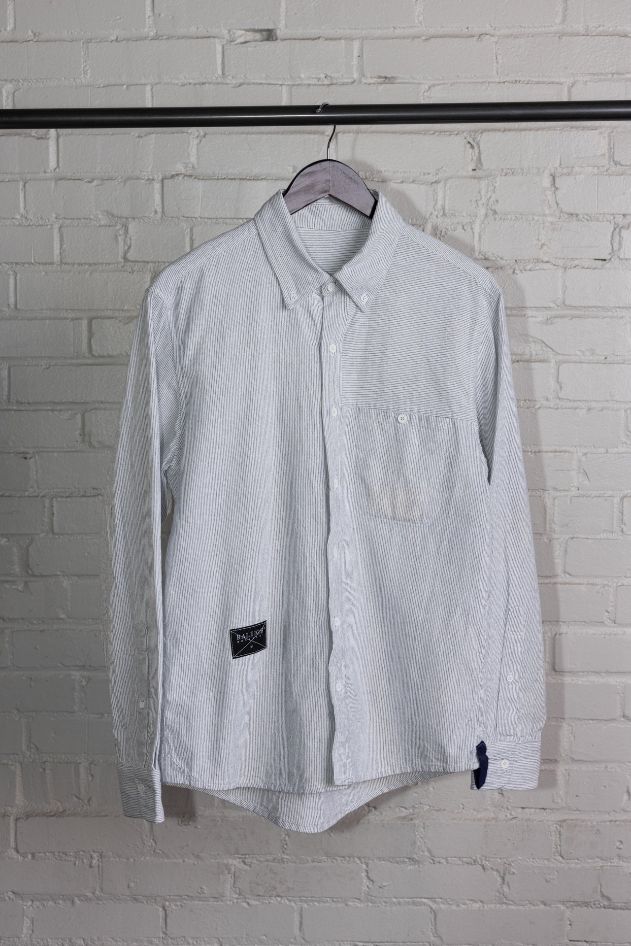 angle: Oxford Ticking Stripe: Man wears white oxford buttonup in ticking stripe