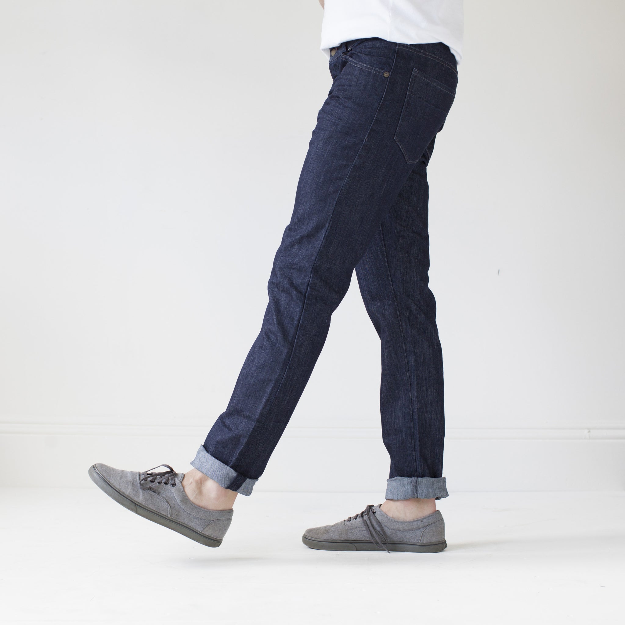 angle: resin rinse  A model wears Raleigh Denim Workshop Jones thin fit in a dark wash, side view