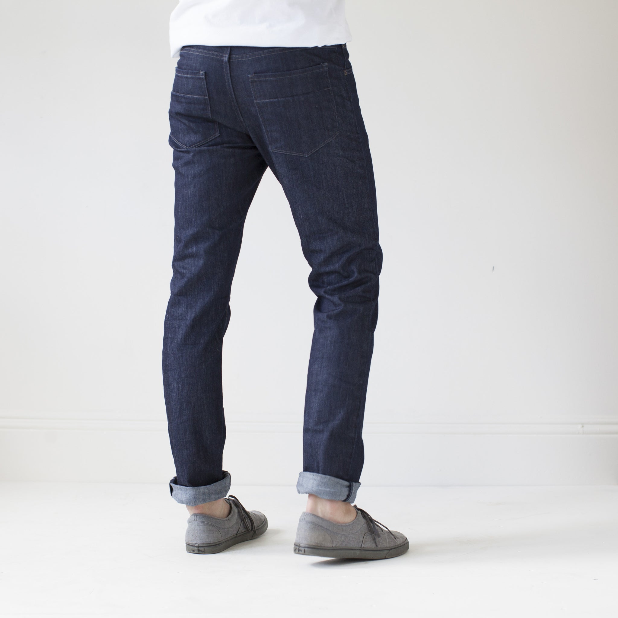 angle: resin rinse  A model wears Raleigh Denim Workshop Jones thin fit in a dark wash, back view