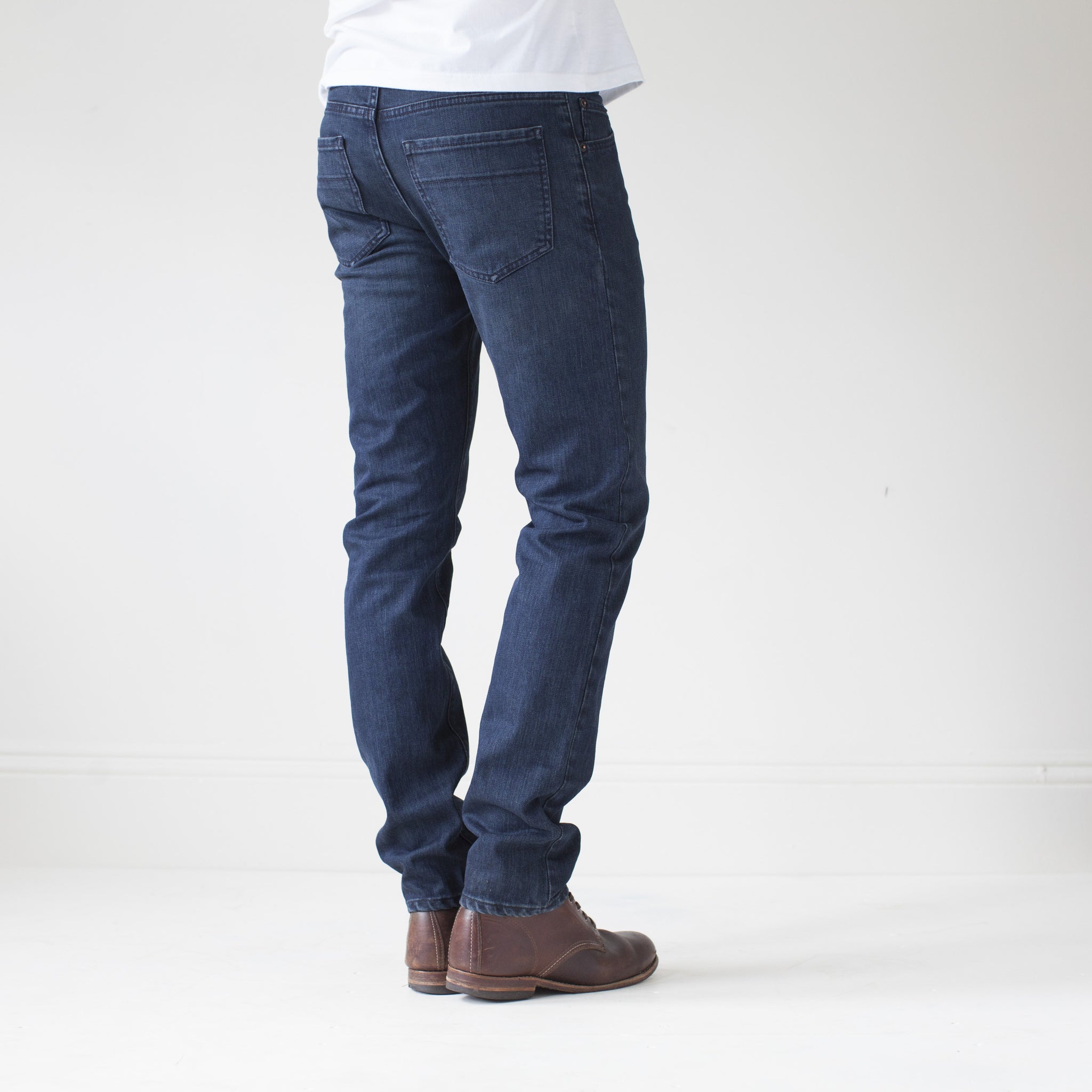 angle: canon  A model wears Raleigh Denim Workshop Martin thin taper fit jeans in original wash, back view