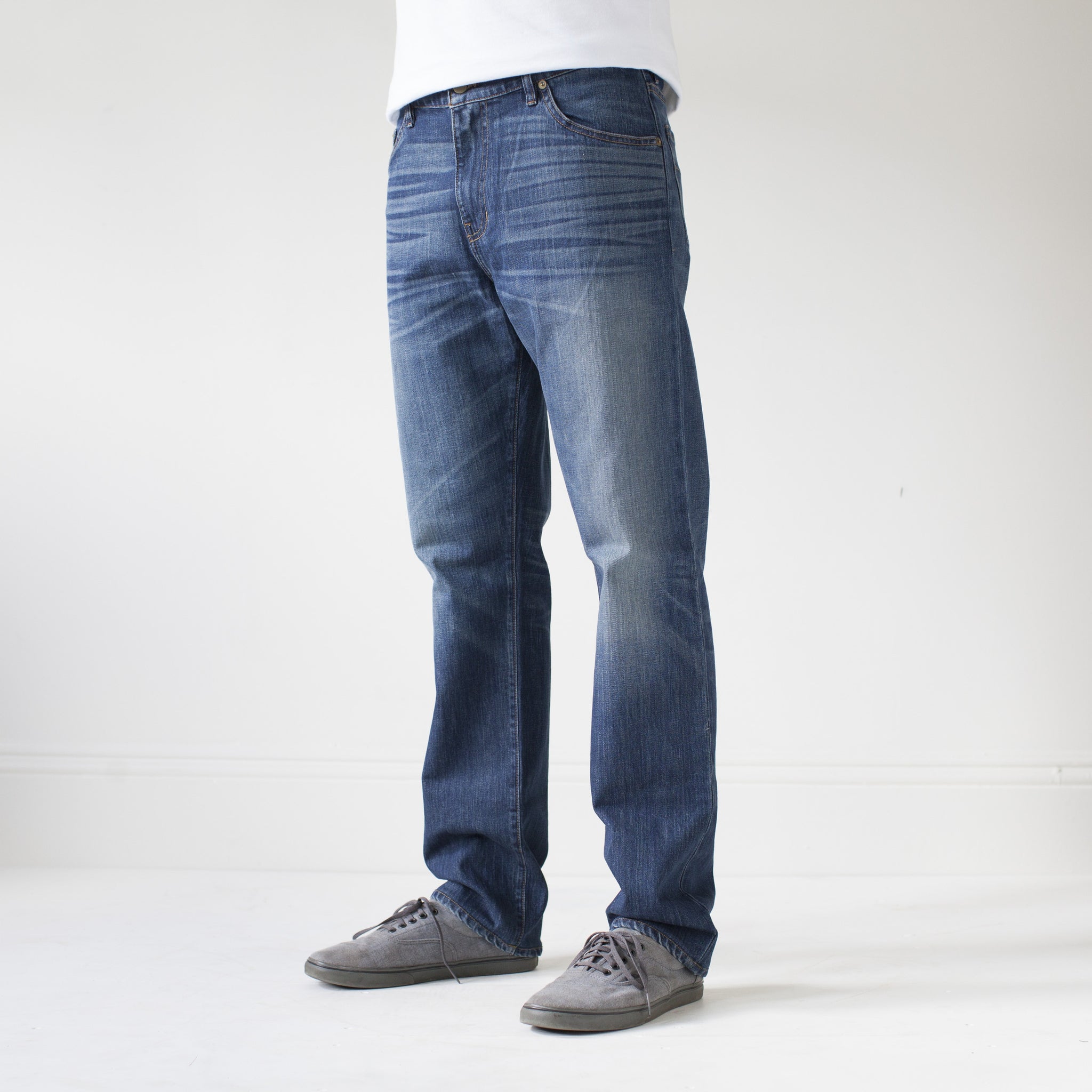 angle: 319  A model wears Raleigh Denim Workshop Alexander work fit jeans in the 319 wash, side view